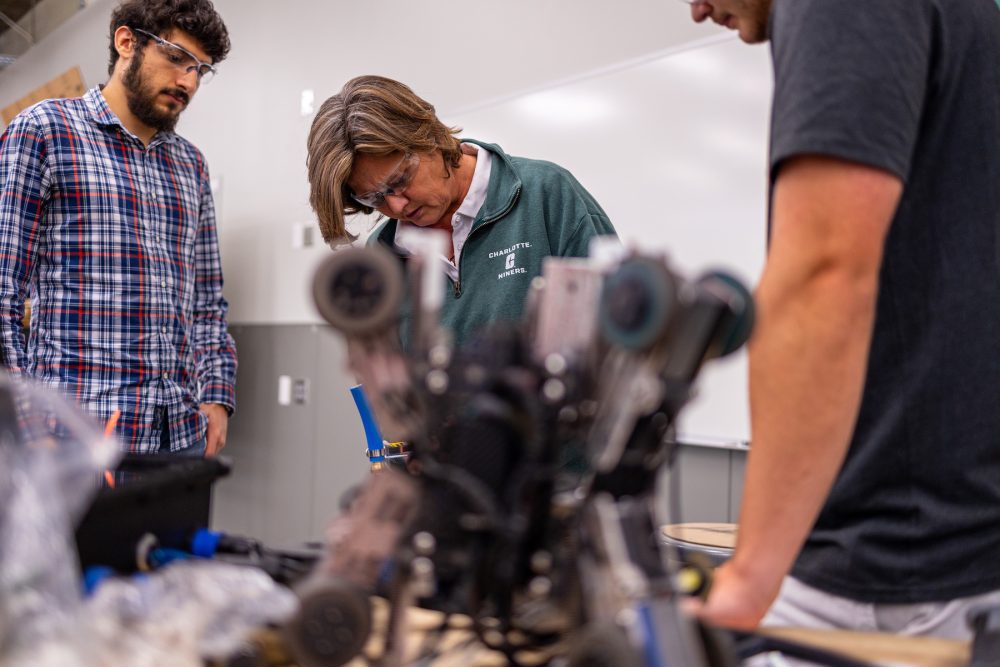 Engineering students work on their Senior Design Projects with professor
